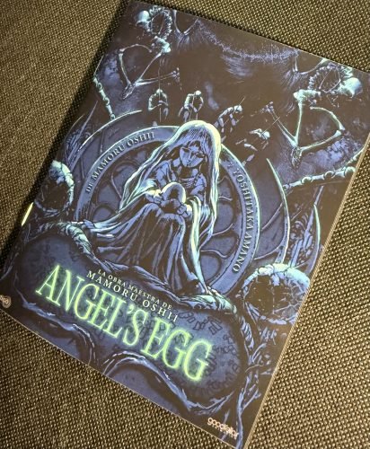 Portada del libreto de Angel’s Egg con la ilustración central de Yoshitaka Amano y el título de la película.